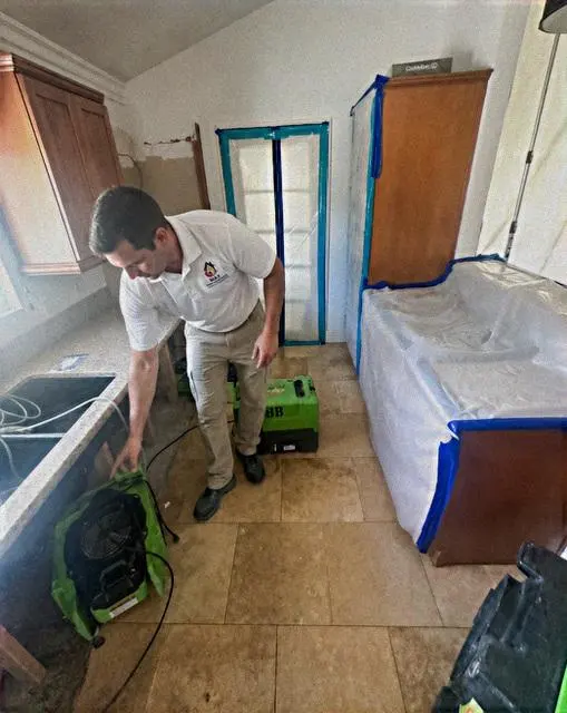 A restoration technician setting up drying equipment in a Forney, TX home